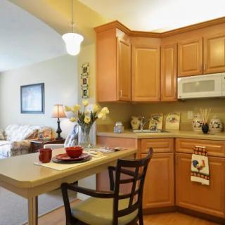 A cozy kitchen with wooden cabinetry and a small dining area.