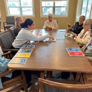 A group of seniors enjoying a card game together indoors.