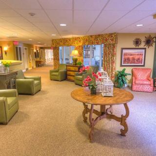 A cozy lobby area featuring comfortable seating, a central table with decorative items, and warm lighting.