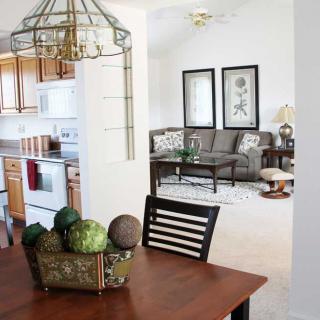 An open space interior featuring a kitchen, dining table, and adjacent living room with modern decor.