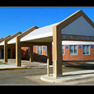 A brick building with a covered entrance and multiple gabled canopies.