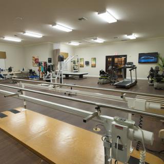A rehabilitation center equipped with parallel bars and exercise machines.