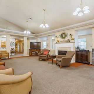 A spacious and well-lit living room featuring comfortable seating, a fireplace, and elegant home decor.