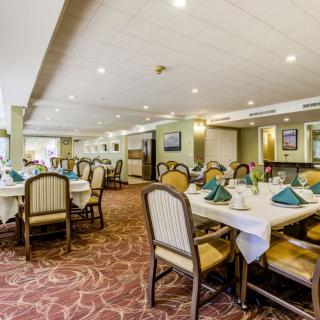 A spacious restaurant dining area with elegantly set tables and comfortable seating.