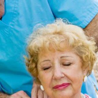 An elderly woman receiving care from a healthcare professional outdoors.