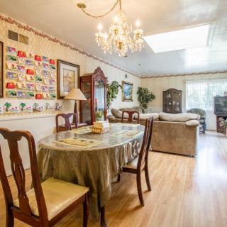 A cozy dining and living area with elegant furnishings and a chandelier.