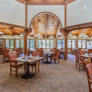 A spacious dining area with elegant wooden interiors and chandeliers.