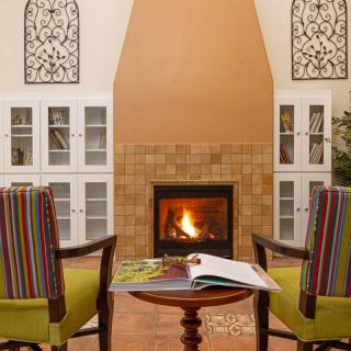 A cozy living room with a warm fireplace and comfortable seating.