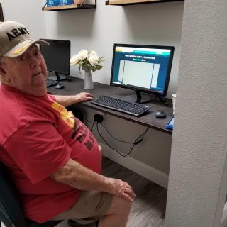 A man sitting at a desk using a computer.