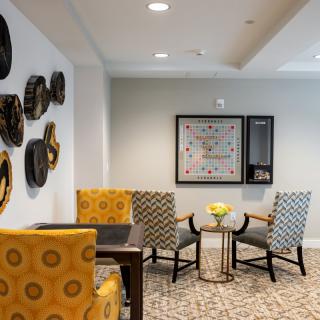 A stylish living room with modern decor, featuring patterned chairs and wall art.