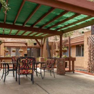 A cozy patio area featuring a pergola, outdoor furniture, and brick accents.