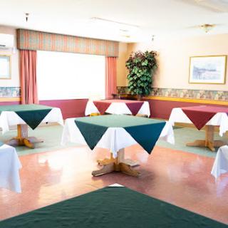 A spacious dining area featuring neatly arranged tables with colorful tablecloths.