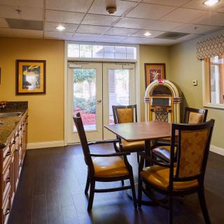 A cozy indoor dining area featuring a table with chairs and a jukebox.