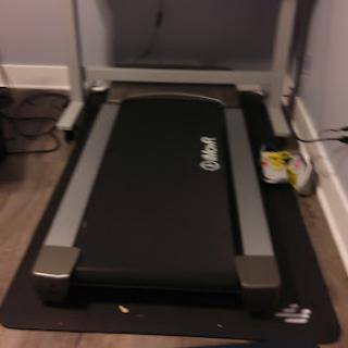 A compact treadmill set up in a home environment, ready for workout sessions.