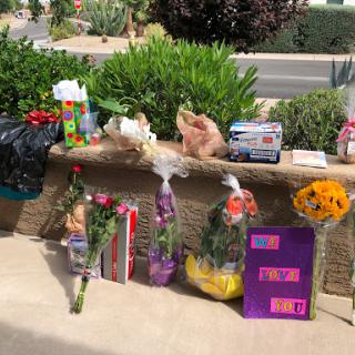 A collection of flowers and gifts displayed outdoors, perfect for a special occasion.