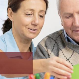 A caregiver assisting an elderly person with an activity.