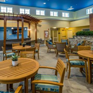 A cozy indoor dining area with wooden tables and chairs, decorated with plants.