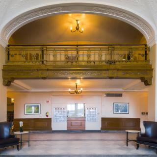 An elegant lobby with a wooden balcony and classic interior design.