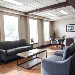 A modern office lounge area with comfortable seating and large windows.
