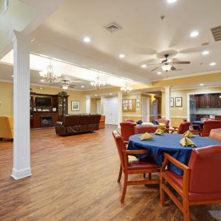A spacious, well-lit living and dining area with wooden flooring and comfortable seating.