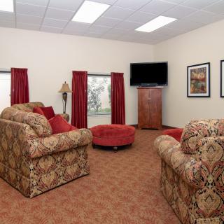 A cozy living room with sofas, a television, and warm decor.