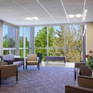 A modern lobby with large windows, comfortable seating, and ample natural light.