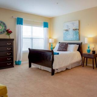 A cozy and well-decorated bedroom with a large bed, dresser, and stylish decor.
