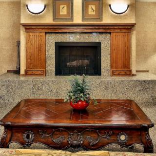A stylish living room featuring a classic wooden coffee table and an elegant fireplace.
