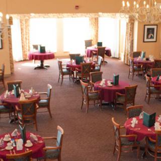 A well-lit dining room with elegantly set tables and comfortable seating.