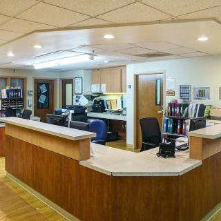 A hospital reception area with office desks and equipment.