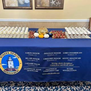 A table set up with a variety of snacks and drinks, covered with a navy-themed tablecloth.