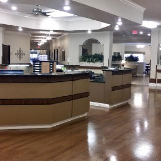 A spacious and modern reception area in a medical facility, featuring sleek counters and a warm wooden floor.