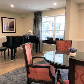 A cozy living room with a grand piano and seating area.