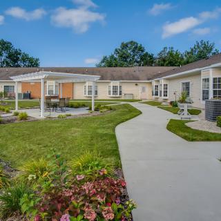 A well-maintained outdoor courtyard with a garden and walking path surrounded by a single-story building.