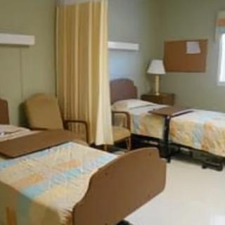 A shared hospital room with two beds and a divider curtain.