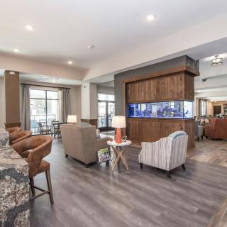 A modern and spacious living room with comfortable seating and wood flooring.