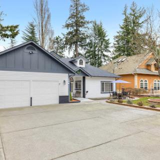 A modern residential home featuring a spacious driveway and beautifully landscaped surroundings.