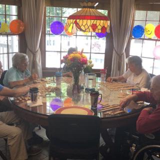 A group of seniors enjoying a meal together in a warmly decorated dining area.