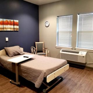 A clean and organized hospital room with a single bed and medical equipment.