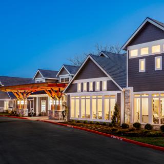 A modern residential building with bright lights during the evening.