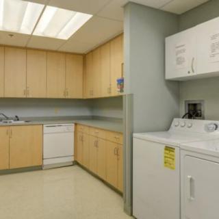 A laundry room with a washer, dryer, and cabinet space in a kitchen area.