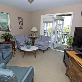 Cozy living room with comfortable seating and a view of the balcony.