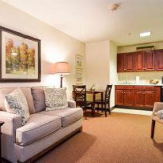 A cozy living area with a sofa, small dining table, and a kitchenette.