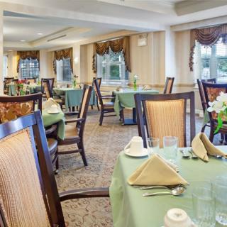 An elegant dining room with neatly arranged tables and chairs, set for a formal meal.