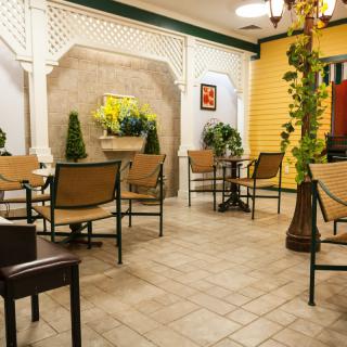 A cozy cafe interior with tables, chairs, and decorative plants.