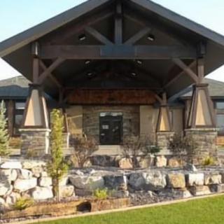 A modern building entrance with a stone facade and wooden beams.