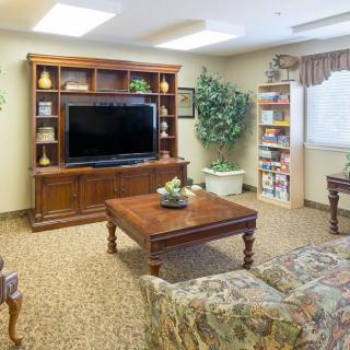 A cozy living room with a large television, wooden furniture, and decorative elements.