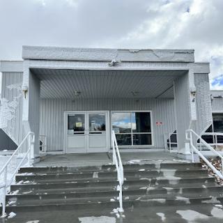 Entrance of a modern metal-clad building with stairs leading up.