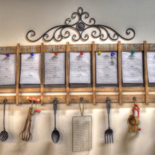 An elegant kitchen menu board featuring organized recipes and functional utensils.