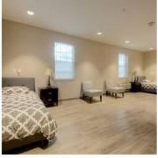 A spacious bedroom with multiple beds and modern furnishings.